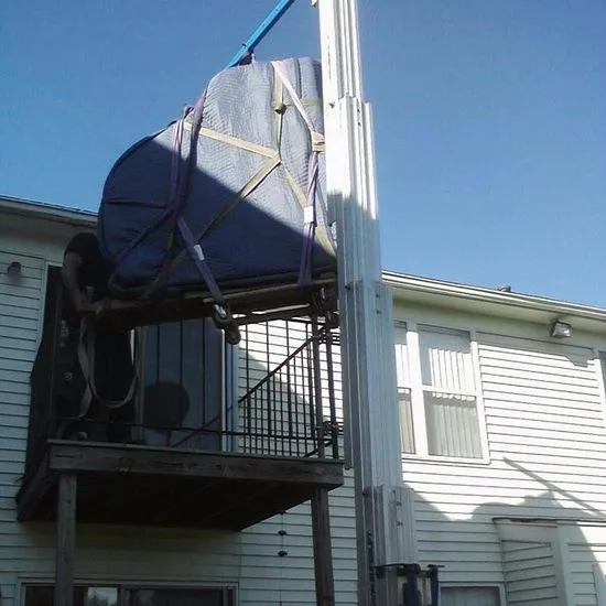 Wrapped grand piano being hoisted up to a second-floor balcony