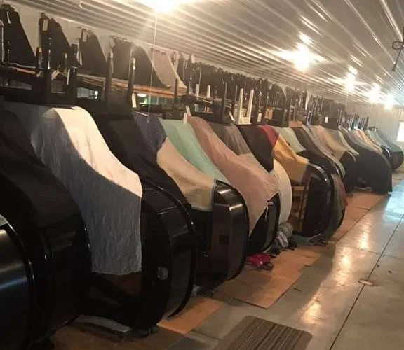Row of covered pianos in a storage building