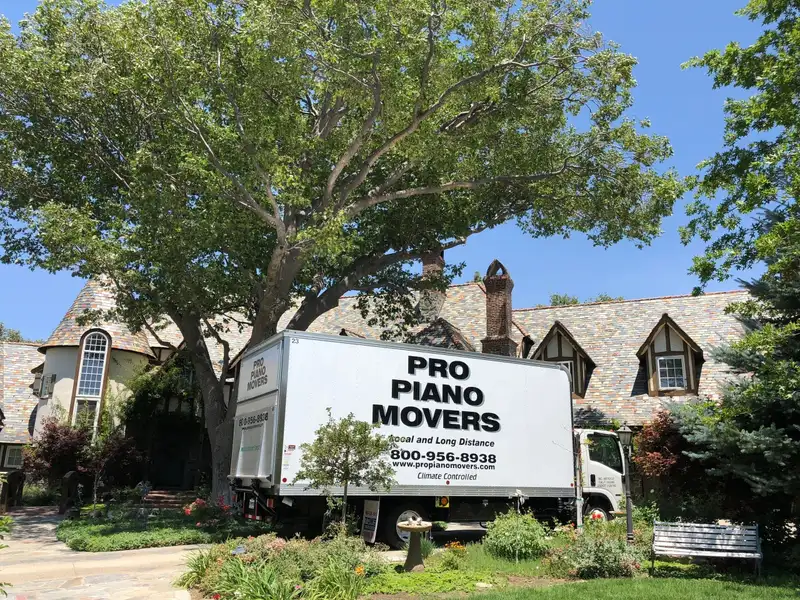 Piano moving box truck parked outside a house