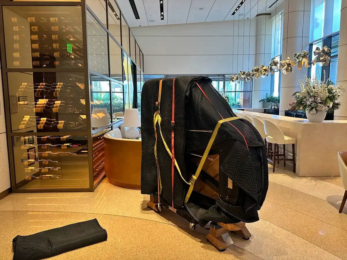 Grand piano wrapped and strapped on a piano board inside a building